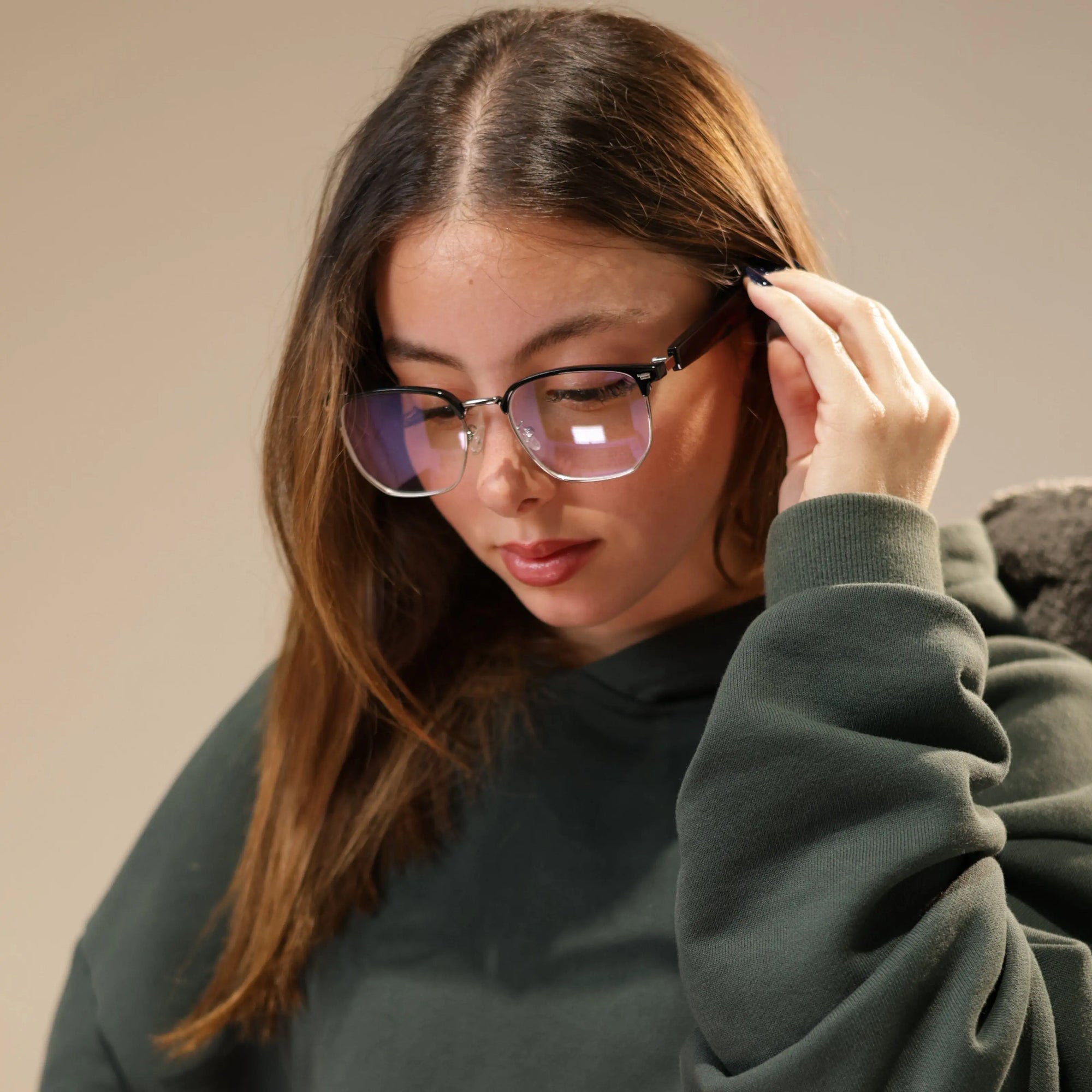 Woman wearing DUSK Halo smart blue light glasses with Bluetooth touch controls for calls and music