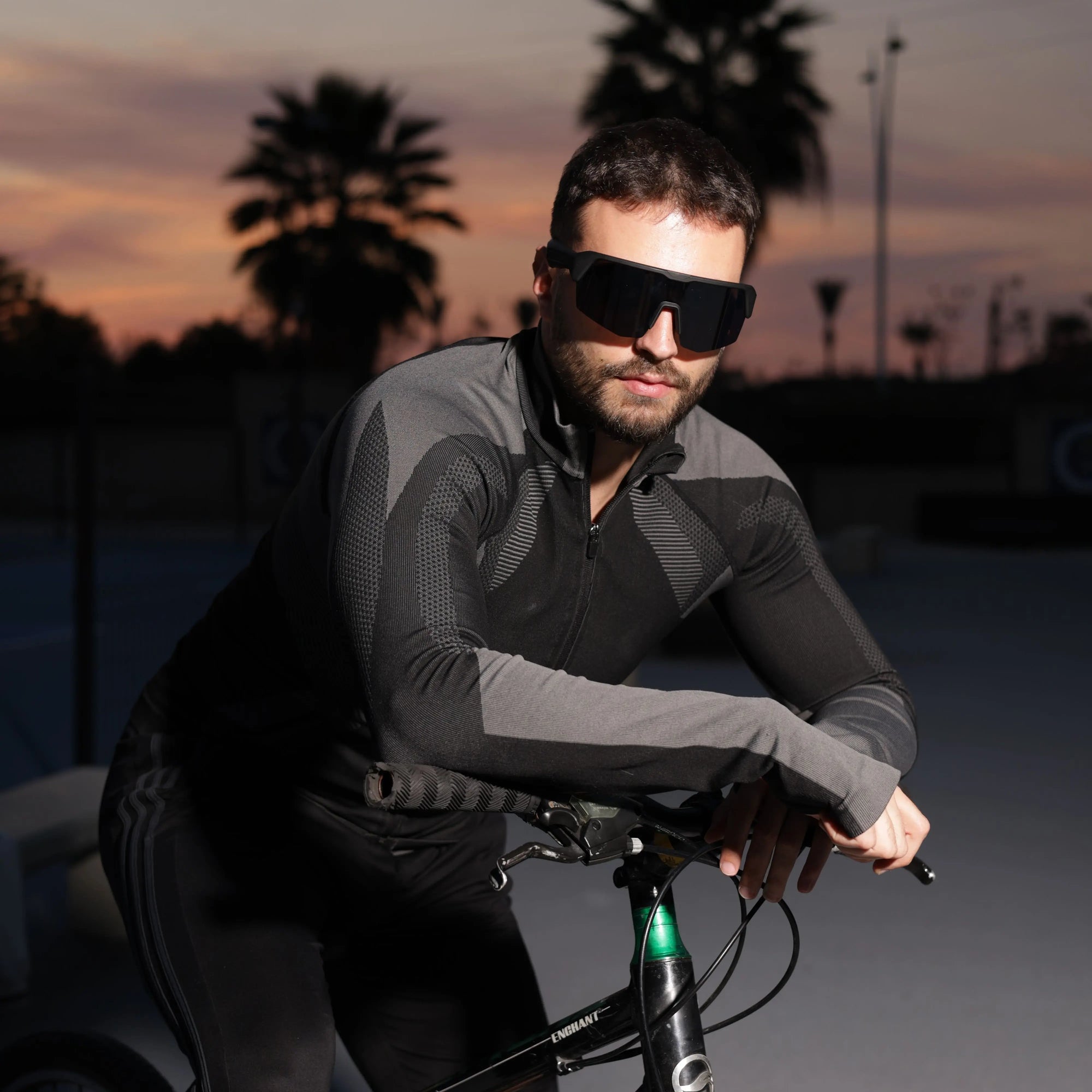 Cyclist wearing DUSK Apex smart sports glasses with Bluetooth audio during sunset ride