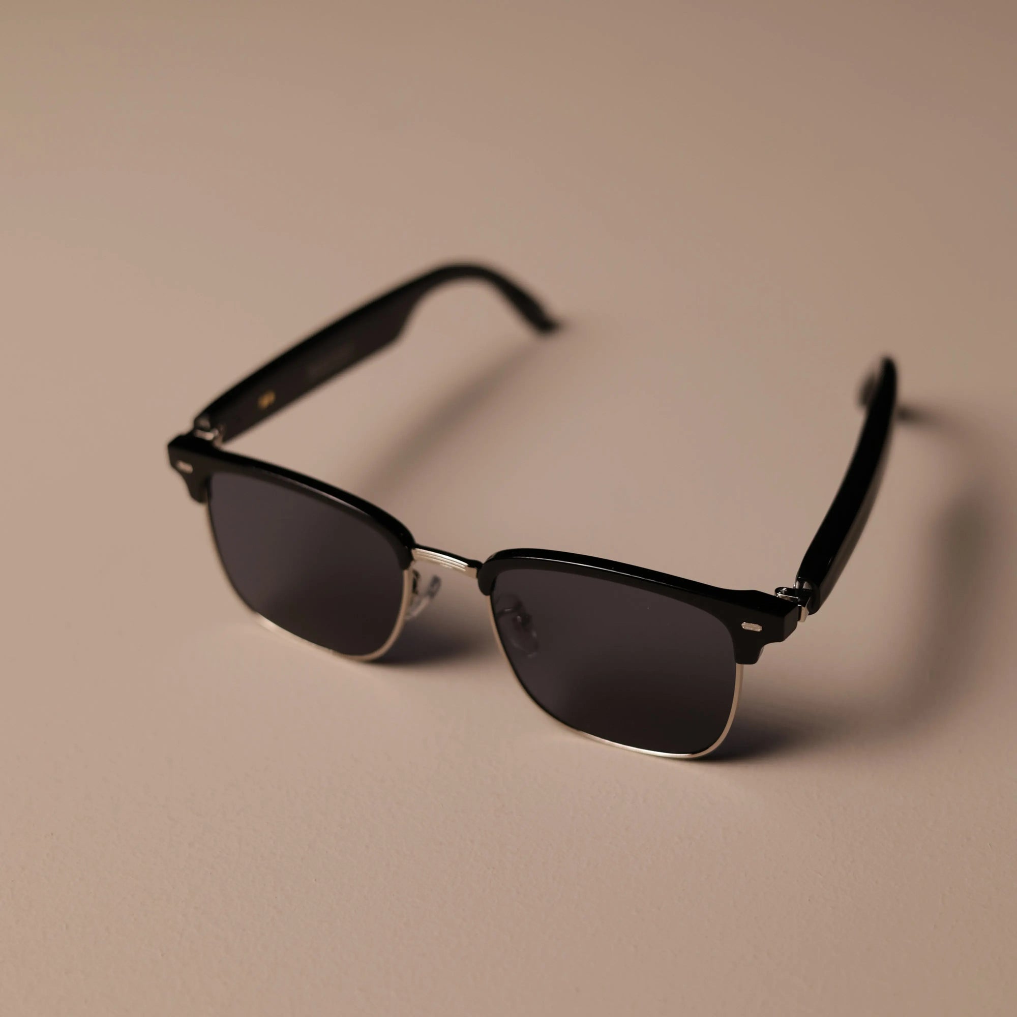 Top-angle view of DUSK Prime smart sunglasses with black half-rim frame and UV-protective lenses