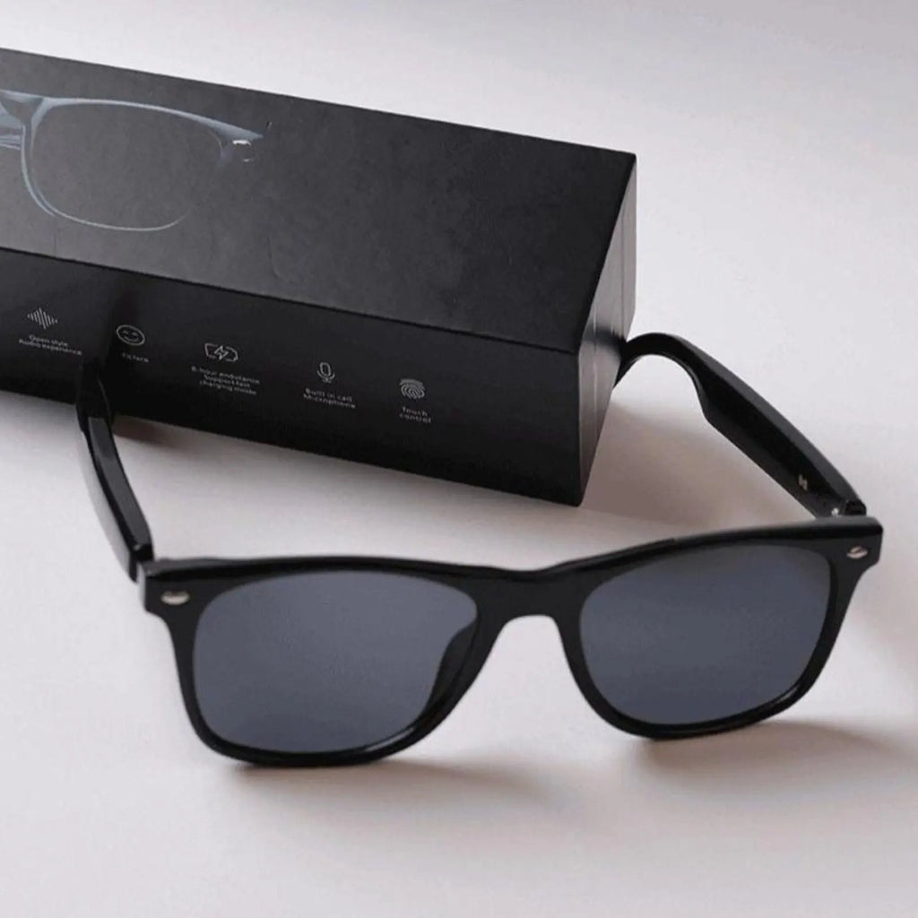 DUSK Prime smart sunglasses with black polarized lenses placed beside branded packaging box