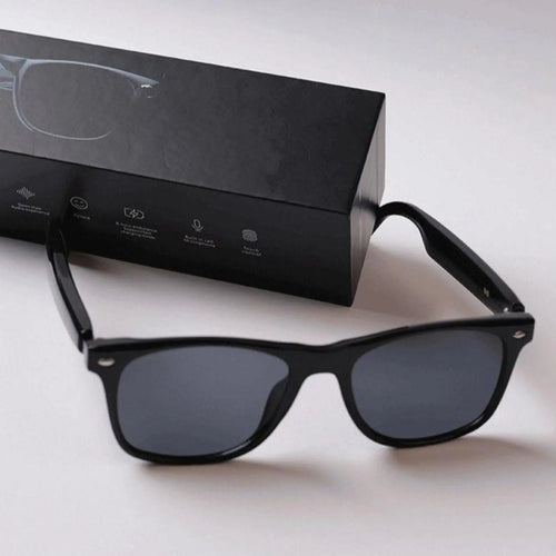 DUSK Prime smart sunglasses with black polarized lenses placed beside branded packaging box
